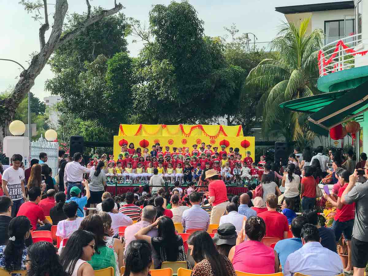 Children singing and people watching