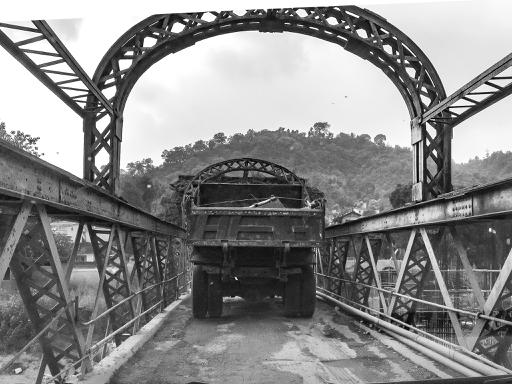 A very old bridge with a broken truck